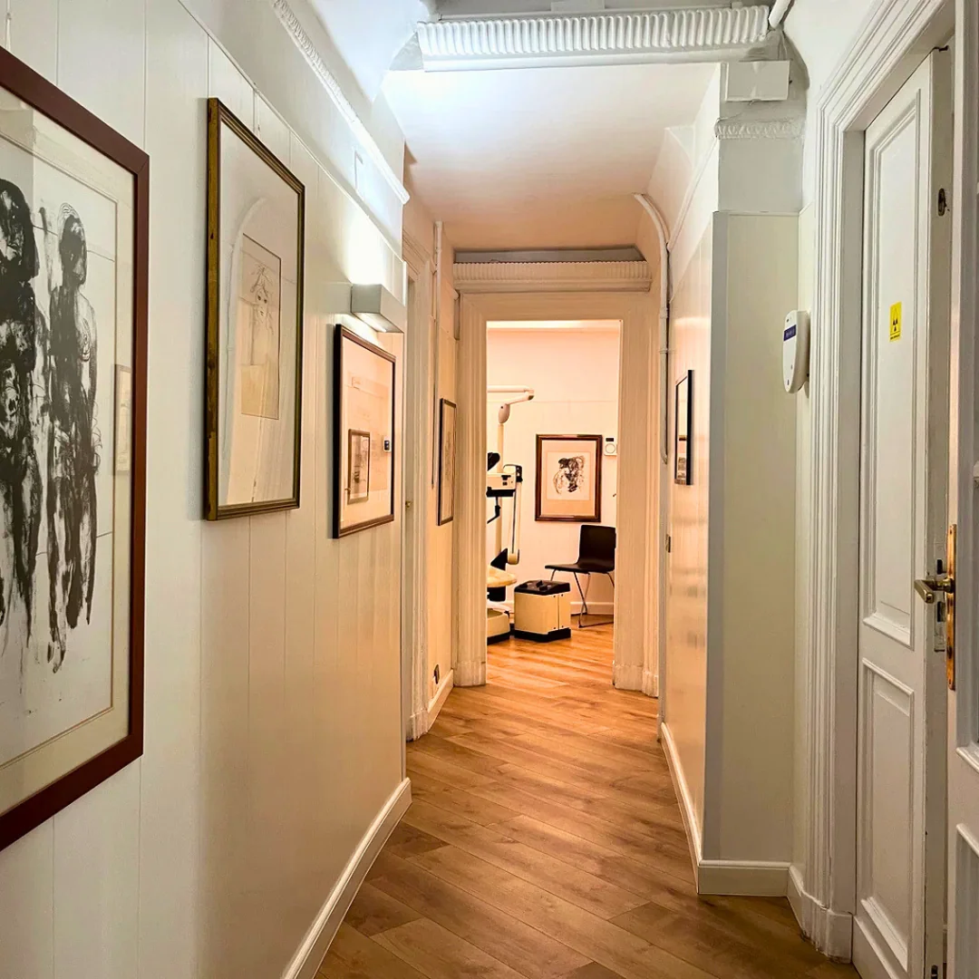 Elegante corridoio con quadri alle pareti che conduce alle sale dello studio dentistico